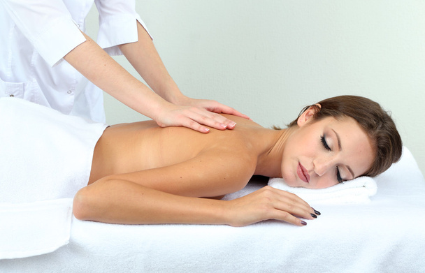 Beautiful young woman on massage table in cosmetic salon close up - Photo, image