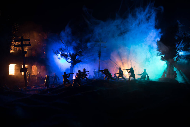 戦争の概念。戦場の霧の空を背景にした軍のシルエット、曇ったスカイラインの下の世界大戦兵士シルエット夜。荒廃した都市での戦い。選択的焦点 - 写真・画像