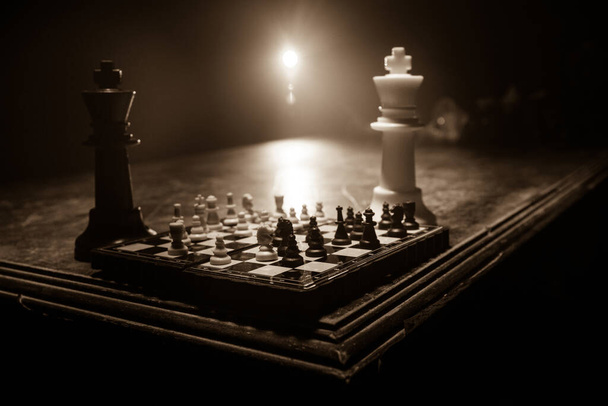Hra na šachovnici s obchodními nápady a konkurencí. Šachové postavy na tmavém pozadí s kouřem a mlhou. Selektivní zaměření - Fotografie, Obrázek