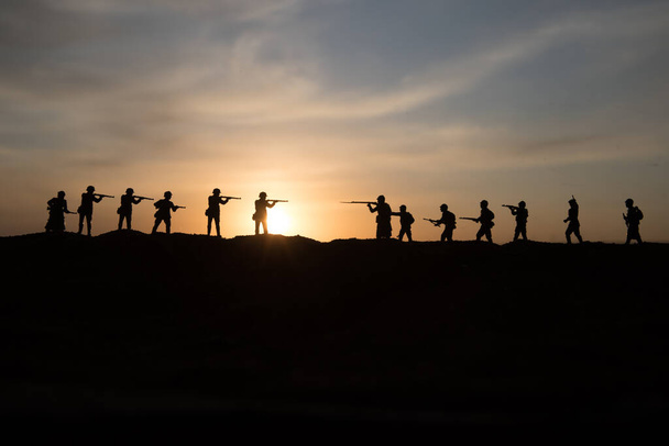 War Concept. Military silhouettes fighting scene on war fog sky background, World War Soldiers Silhouette Below Cloudy Skyline sunset. Selective focus - Zdjęcie, obraz