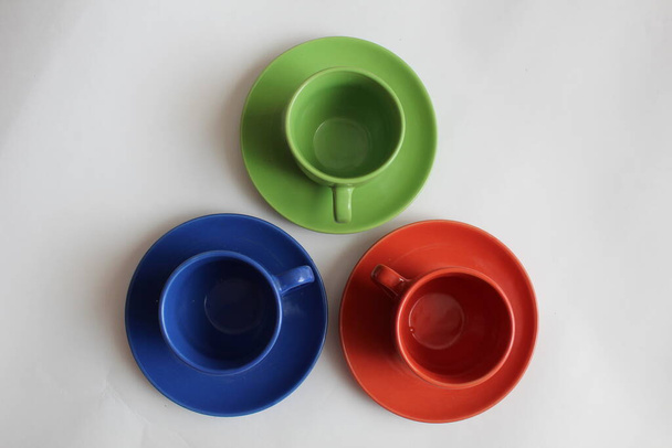 tres copas multicolores y platillos de pie juntos en un círculo azul rojo verde
 - Foto, Imagen