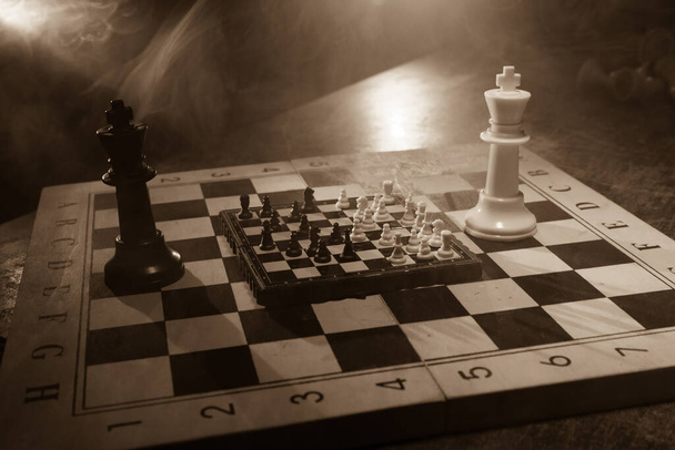 ビジネスのアイデアと競争のチェスボードゲームの概念。煙と霧と暗い背景にチェスの数字。選択フォーカス - 写真・画像