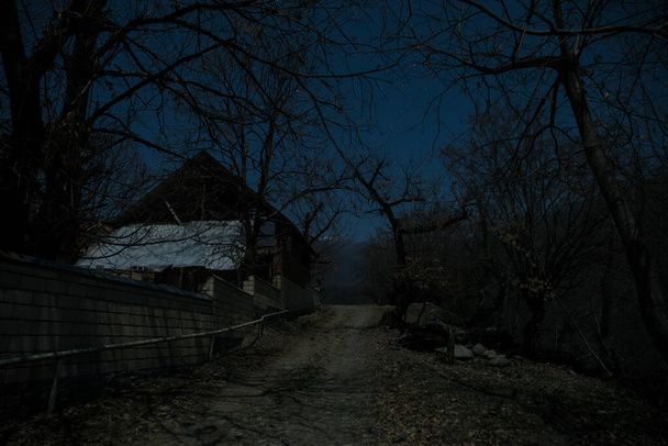 Full moon over quiet village at night. Beautiful night landscape of mountain village under the moonlight. Azerbaijan nature. Long exposure shot - Photo, Image
