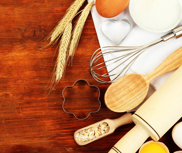 Cooking concept. Basic baking ingredients and kitchen tools on wooden table - Foto, Bild
