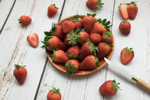 A closeup shot of beautiful fresh strawberries on a wooden surface - Foto, Imagen