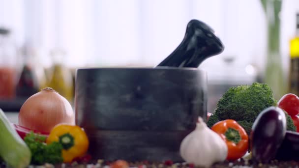 Kräuter, getrocknete Paprika, Gewürze und Knoblauch werden in eine hölzerne Knoblauchpresse gegossen - Filmmaterial, Video