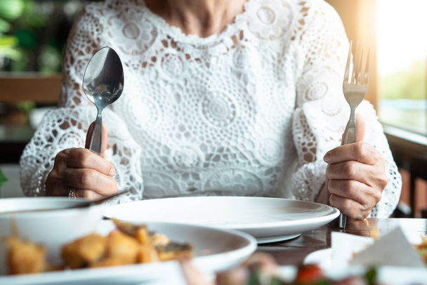 Boldog sikeres idős nők szembesülnek kapuzárási pánik üres tányér étkezési rendellenesség anorexia étel unalmas egészségügyi probléma. Idős nő ül az asztalon egyedül megállítani enni fogyás, diéta, cukorbetegség. - Fotó, kép