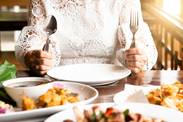 Happy successful old aging women facing midlife crisis empty plate eating disorder anorexia food boring health issue. Senior female sitting on table alone stop eat weight lose, diet, diabetes illness. - Photo, Image