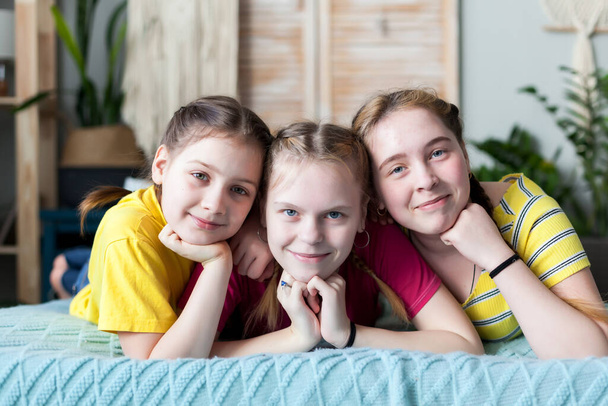 Retrato de três irmãs adolescentes na cama em casa
.  - Foto, Imagem