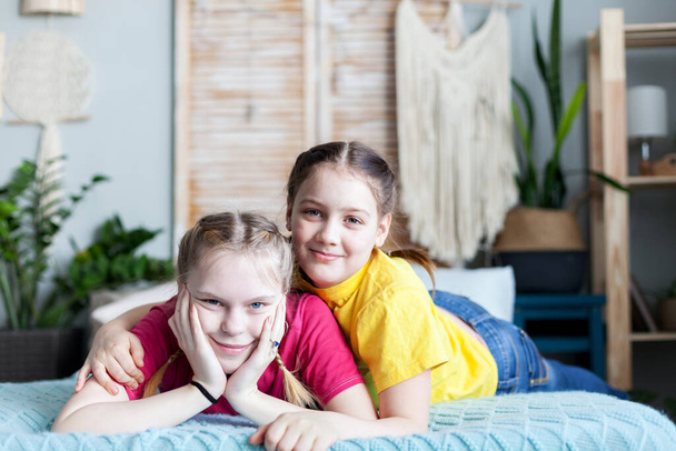 Twee tienervriendinnen die thuis op bed liggen. - Foto, afbeelding