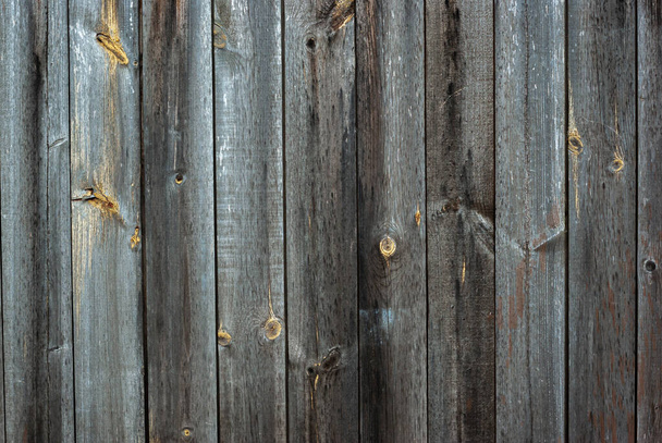 Shabby old grey-brown fence, abandoned and forgotten, a background of wooden planks, in the style of rustic, grunge, old fashion - Valokuva, kuva