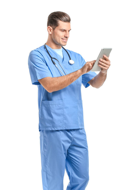 Portrait of young male doctor with tablet computer on white background - Photo, Image