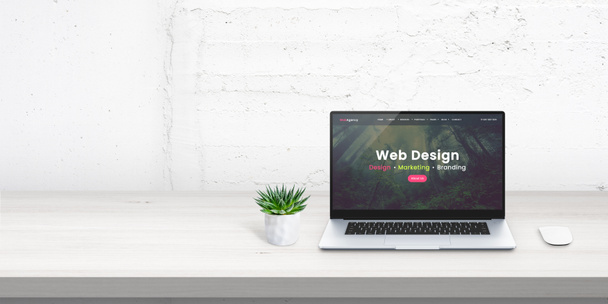 Web design studio promo web site koncept na displeji notebooku. Volné místo vedle pro promo text na bílé stěně - Fotografie, Obrázek