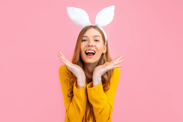 Holiday season of rabbit and eggs. Happy stylish woman in Easter Bunny ears isolated on pink background. - Foto, Imagem