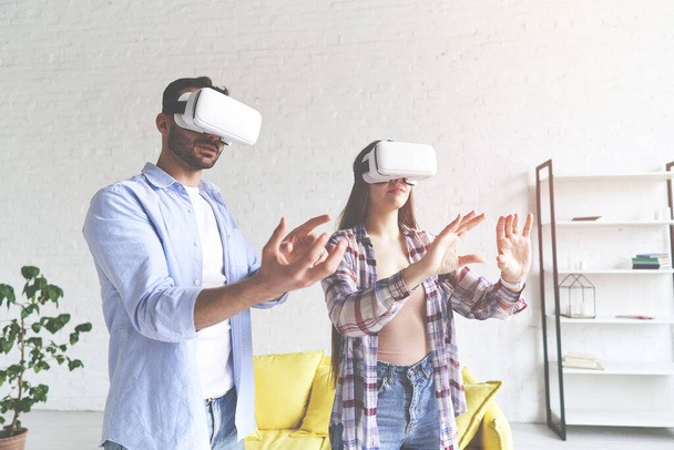 Молодая счастливая пара веселится в очках для наушников от VR
 - Фото, изображение