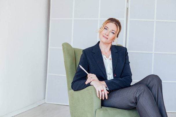 business woman psychologist at work in green chair - Foto, afbeelding