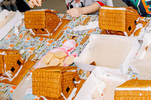 ジンジャーブレッドクッキーサンタのためのクッキーの家、子供たちは家を飾る、食べる準備をしています - 写真・画像