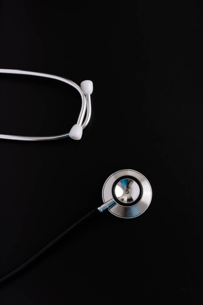 Stethoscope isolated on black, top view. Medical tool - Zdjęcie, obraz