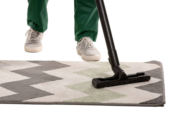 Young man hoovering carpet against white background - Photo, Image