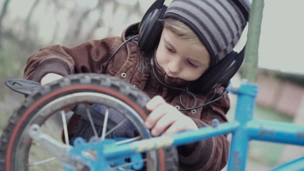 Chłopiec w wieku 5 lat naprawia rower dla dzieci.. - Materiał filmowy, wideo