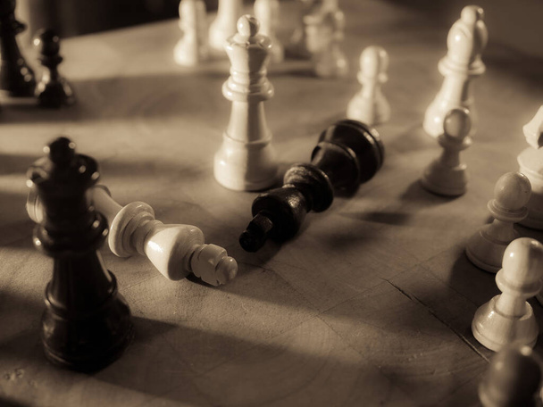Sakk darabok és konyhakés. Stratégiai játék. Egy 64 négyzetméteres fekete-fehér táblán játsszák.. - Fotó, kép