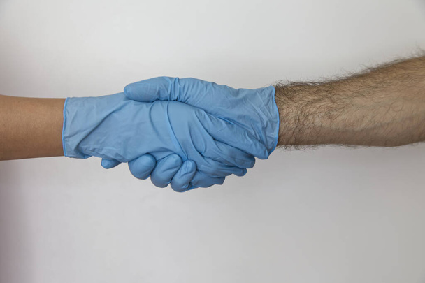 Beyaz zemin üzerinde izole edilmiş ölümcül virüse karşı lateks eldivenler - Fotoğraf, Görsel