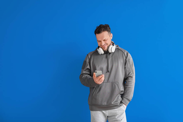 Stylish man with mobile phone on color background - Foto, Bild