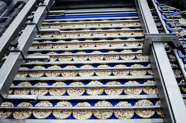 kerek diétás kenyerek válogatása a szállítószalagon automatizált gépen - Fotó, kép
