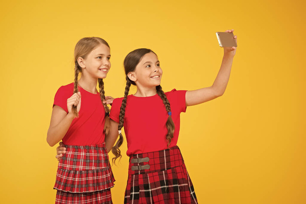 lets make pic. girls in uniform. small girls making selfie on phone. having fun. sisterhood and friendship. happy knowledge day. childhood happiness. education concept. back to school. social network - Fotoğraf, Görsel