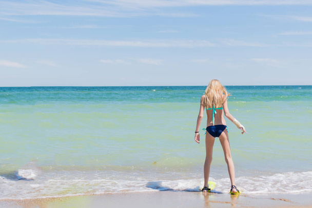 A teenage girl in fins by the sea, ocean. - Photo, image