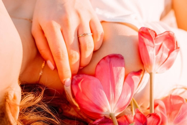 bella ragazza siede su un plaid con un mazzo di tulipani. Colazione romantica all'alba con il sole
. - Foto, immagini