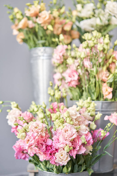 美しいピンク、白、花瓶の緑の色のユーズヤの花束。花屋の寒い部屋の春の花. - 写真・画像