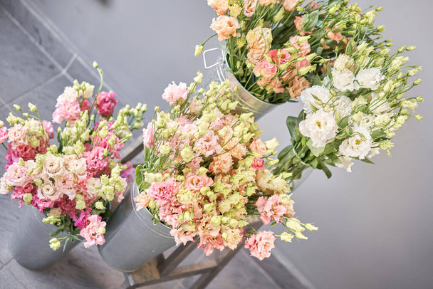 Bouquet von schönen rosa, weißen, grünen Farbe Eustoma in der Vase. Frühlingsblumen im Kühlraum des Blumenladens. - Foto, Bild