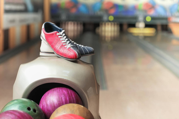 Stand with balls and shoes in bowling club - Фото, изображение