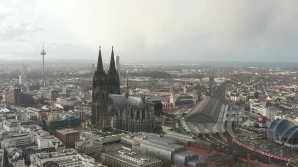 AERIAL: Rondcirkelen in de prachtige kathedraal van Keulen met centraal station in mooi wazig zonlicht  - Video