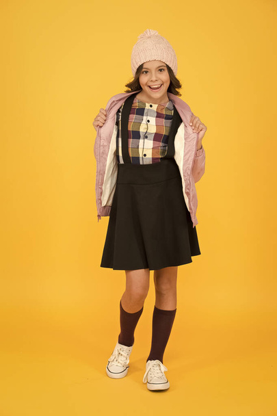 Welcome to school. small girl in uniform. cheerful child yellow background. beauty and fashion for kid. back to school. ready for winter vacation. warm autumn clothes. get knowledge of style - Foto, Imagem