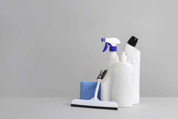 Set of cleaning supplies on grey background - Foto, afbeelding