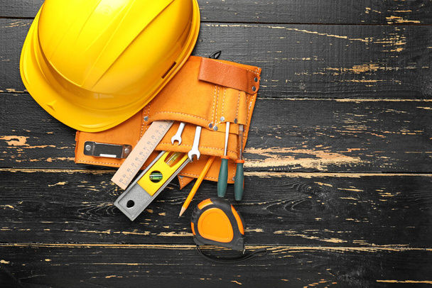 Builder's tools and hardhat on wooden background - Фото, изображение