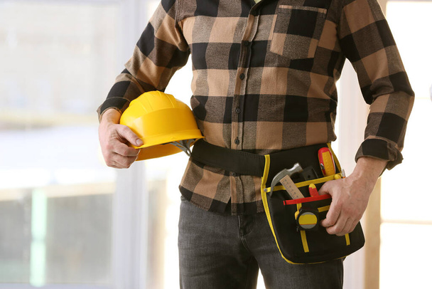 Constructor masculino con hardhat y herramientas en la oficina
 - Foto, imagen