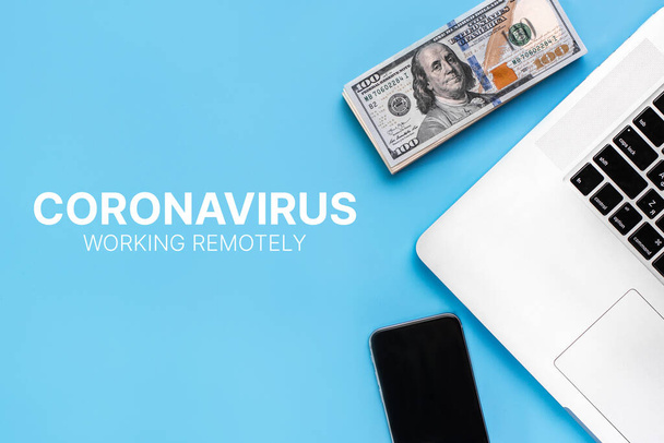 The concept of working from home during a coronavirus epidemic. People work remotely. Laptop and banknotes on a blue background. Covid-19 - Photo, Image