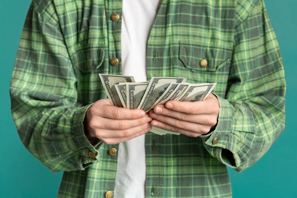Erfolgskonzept. Unerkennbarer junger Mann mit Geld auf farbigem Hintergrund, Nahaufnahme - Foto, Bild