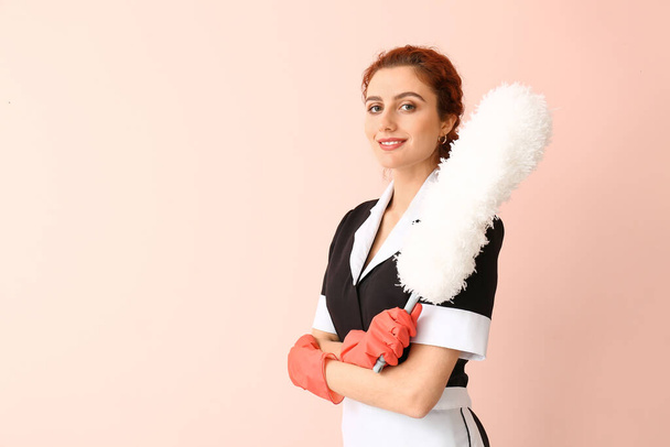Beautiful young chambermaid on color background - Fotó, kép