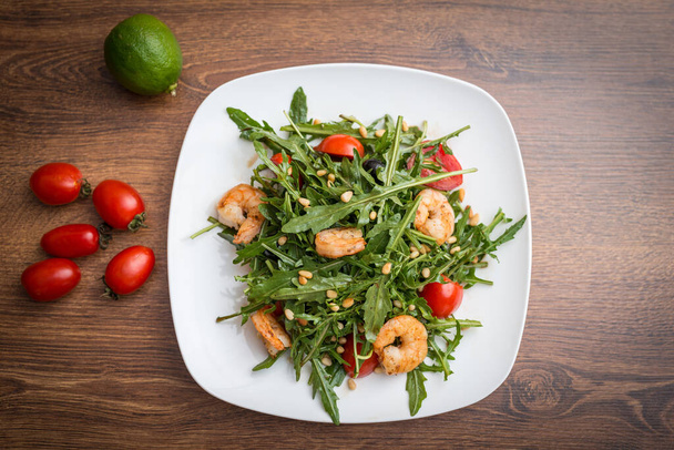 A delicious salad with arugula, cherry tomatoes and shrimps. - Valokuva, kuva