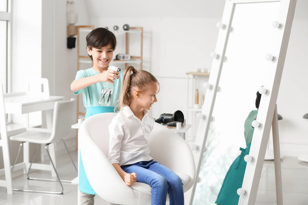 Cute little hairdresser working with client in salon - Photo, Image