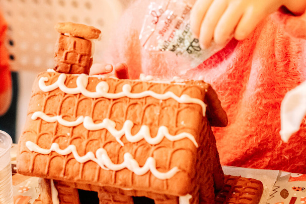 cooking gingerbread cookies, a house of cookies for Santa, kids are preparing to eat, decorating the house - Photo, Image
