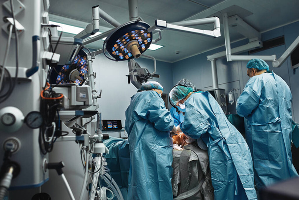 Zespół profesjonalnych chirurgów pracuje na sali operacyjnej. Prawdziwa operacja usunięcia guza nowotworowego. Ratowanie życia, nowoczesna sala operacyjna. Walcz o życie. - Zdjęcie, obraz