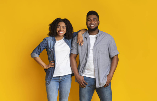 Frescos Millennials. Atraente jovem casal negro posando juntos sobre fundo amarelo
 - Foto, Imagem
