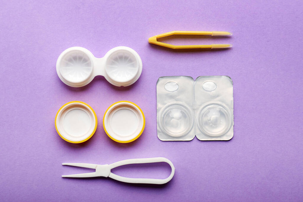 Containers for contact lenses and tweezers on color background - Foto, Imagem