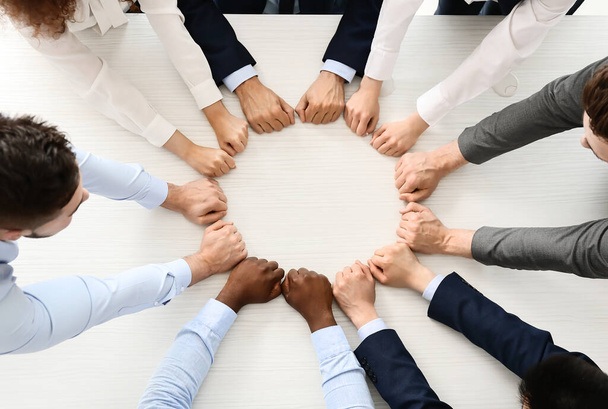 Gruppo di uomini d'affari che mettono insieme le mani in ufficio, vista dall'alto. Concetto di unità
 - Foto, immagini