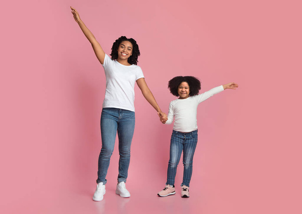 Happy Smiling Black Mom And Daughter Posing With Raised Hands - Foto, imagen